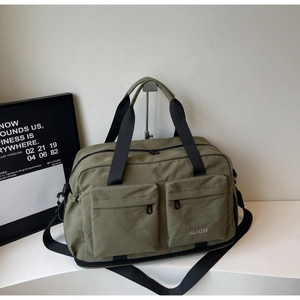 Close-up of olive green travel bag showing dual front zipper pockets and durable handles