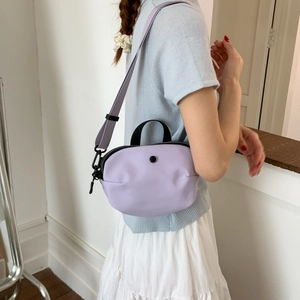 Sac bandoulière demi-lune violet clair avec poignée noire et bouton décoratif