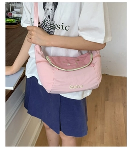 Detail showing pink canvas crescent sling bag with Guava embroidery and green trim