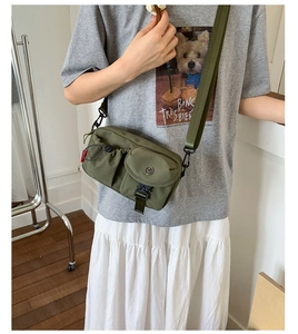 Detail of army green nylon crossbody bag with multi-pocket design and adjustable strap