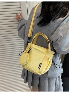 Bright yellow nylon bucket bag with crossbody strap and small round coin purse