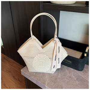 Détail du sac cabas crème ajouré avec motifs découpés au laser et foulard en soie