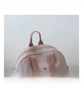 Close-up of pink puff nylon backpack showing wrinkled texture and comfortable top handle