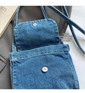 Detail shot of strong magnetic closure and denim texture on casual crossbody bag