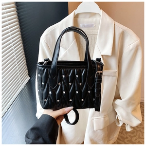 Detail of black quilted leather bucket bag with rhinestones and adjustable strap
