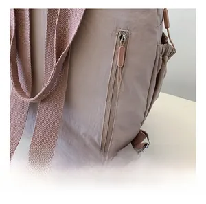 Close-up of smooth metal zippers and side pockets on this lightweight nylon backpack