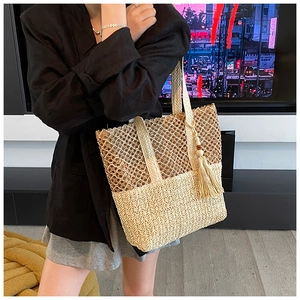 Detailed look at beige hollow woven straw shoulder bag with tassels and wooden beads