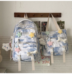 Blue and white tie-dye backpack detail with plush charms and JIANING SUNDAY label