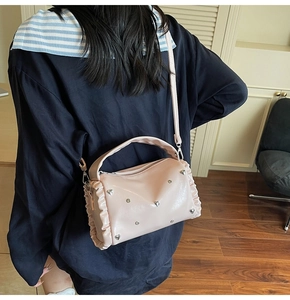 Pink ruffled tote bag with silver heart studs shown from back on person