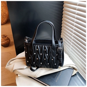 Detail of quilted leather bucket bag with silver rhinestones and adjustable strap
