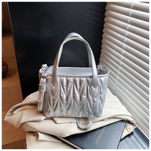 Close-up of silver quilted bucket bag with rhinestones and thin adjustable shoulder strap