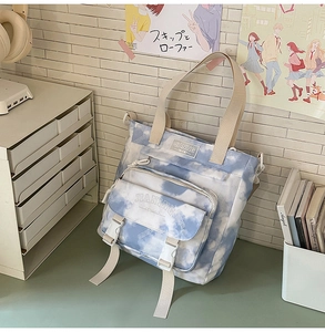 Detailed view of the blue and white tie-dye backpack with buckle closure and front pocket