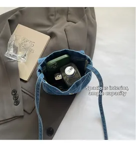 Detail view showing large interior capacity of blue denim crossbody bag for essentials