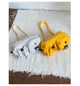 Detail of waterproof nylon crossbody bags with multiple pockets in white and yellow