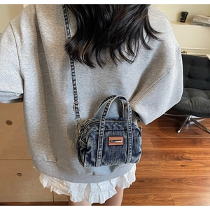 Detailed side view of vintage washed denim mini crossbody bag worn with casual outfit
