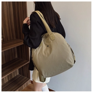 Detail view of large olive green waterproof backpack with wide straps for travel use