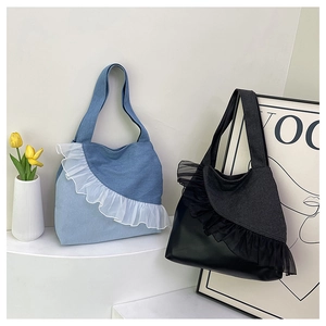 Detail view of denim tote bags with mesh ruffle edges in light blue and black styles