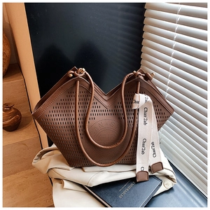 Détail du grand sac cabas marron avec motif découpé au laser et ruban de soie