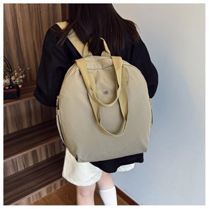 Rear view of a model wearing the khaki waterproof canvas backpack for daily travel