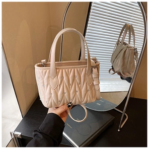 Detail view of beige quilted handbag with sparkling rhinestones and silver mirror reflection