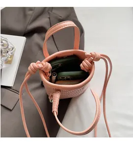 Vue détaillée de l'intérieur du sac seau rose tressé montrant sa capacité de rangement