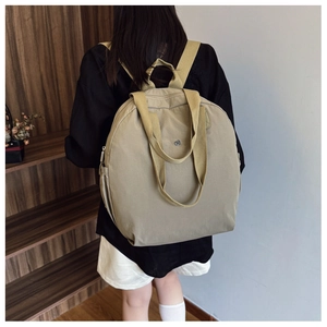 Rear view of a model wearing a large khaki waterproof backpack with wide straps