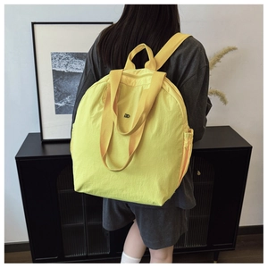 Detail view of bright yellow waterproof nylon backpack with side drawstring pocket