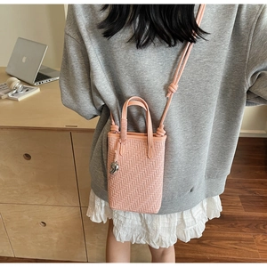 Détail du mini sac cabas rose tressé avec pendentif lune argenté et bandoulière