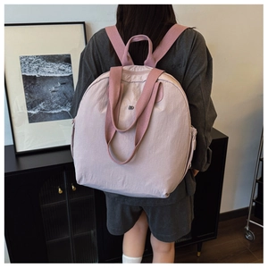 Macro detail of pink waterproof nylon backpack showing the stitching and DD logo branding
