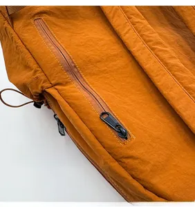 Detail view of the nylon backpack featuring a side pocket with a black metal zipper