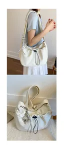 Detail of off-white tote bag featuring black drawstring and silver butterfly pendant charms