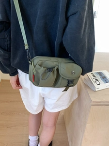 Army green nylon tactical crossbody bag with multiple pockets worn by model