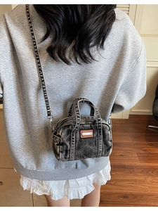 Vintage acid wash denim crossbody pillow bag with top handle and adjustable strap in black