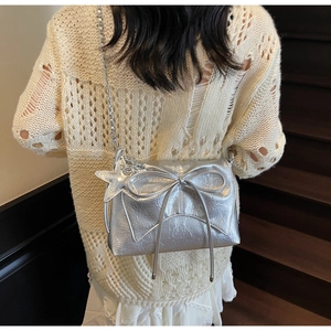 Silver metallic pleated shoulder bag with oversized bow and starfish charm detail
