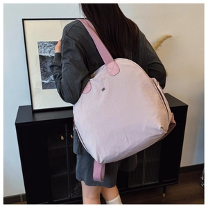 Detail of a large lilac waterproof fabric backpack with pink straps and metallic logo