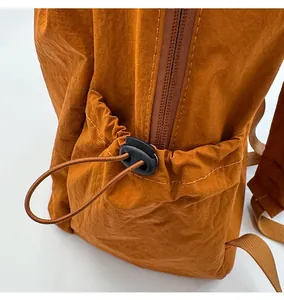 Detail of outdoor nylon backpack featuring side drawstring pocket and smooth zipper