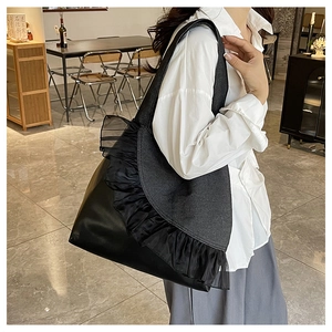 Detail view of black tote bag with large capacity mesh ruffles and faux leather finish