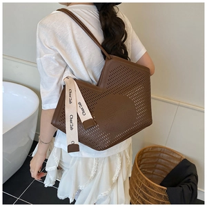 Grand sac cabas marron ajouré au laser avec bandoulière en cuir dans un cadre de maison