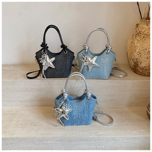 Three mini bucket bags in denim and sequins shown on stone steps with star charms
