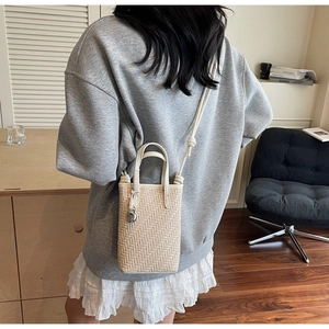 Sac à main tissé beige chic avec bandoulière présenté dans un décor de style de vie