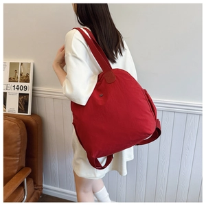Detail of red waterproof nylon backpack with side pockets and durable shoulder straps