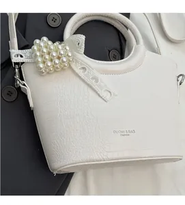 Detailed macro view of white crocodile pattern texture with pearl heart bag charm