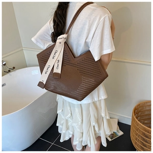 Détail du cabas marron ajouré avec motifs géométriques au laser et ruban décoratif