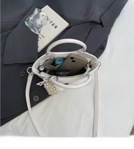 Top view of open white bucket bag showing internal space for phone and makeup