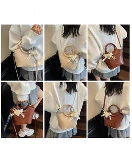 Detail showing high-quality crocodile texture leather bag with elegant pearl bow charm
