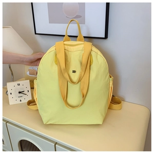 Detailed view of yellow macaron waterproof nylon backpack with reinforced handle and logo