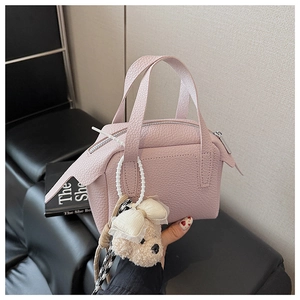 Détail du mini sac carré en cuir litchi rose avec breloque d'ours en peluche mignon