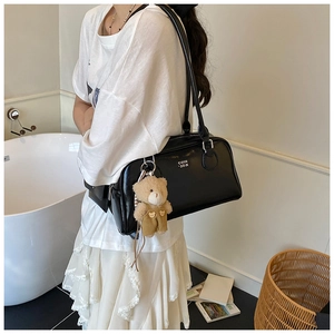 Dettaglio borsa Boston trapuntata nera con logo bianco e ciondolo a forma di orsetto