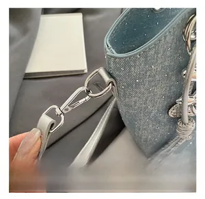 Detailed shot of sparkling rhinestone denim bucket bag with silver metal swivel hooks