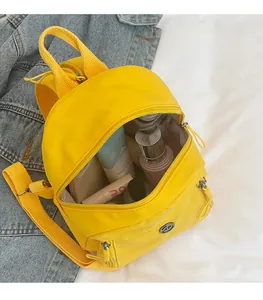 Detailansicht eines gelben Nylon-Minirucksacks mit geräumigem Innenfach und Silber-Reißverschluss